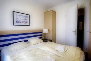 a bedroom with a white bed with a blue and white headboard at Am Kurhaus 318 PP 81 in Zingst