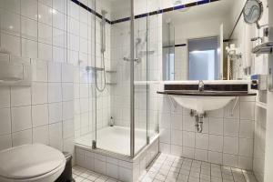 ein Bad mit einer Dusche, einem WC und einem Waschbecken in der Unterkunft Am Kurhaus 318 PP 81 in Zingst
