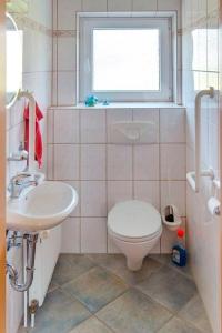 ein Bad mit einem WC, einem Waschbecken und einem Fenster in der Unterkunft Ferienhaus Dittrich in Eckernförde