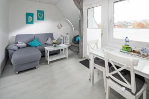 uma sala de estar com um sofá e uma mesa em Skippers Cabin em Norddeich