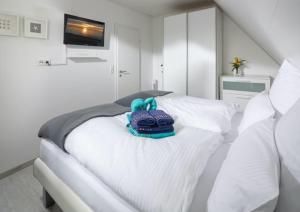 uma cama branca com um saco azul em cima em Skippers Cabin em Norddeich