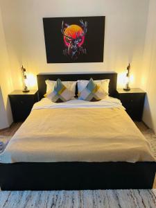 ein Schlafzimmer mit einem Bett mit zwei Nachttischen und zwei Lampen in der Unterkunft Ama Apartament - Cota 1000 Sinaia in Sinaia