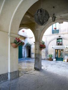 un arco en un edificio con macetas de flores y una lámpara de araña en Mini Hotel Wf2 Caltagirone en Caltagirone