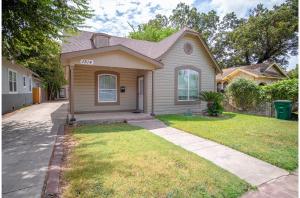 uma casa com um jardim de relva em frente em Florida St Nice Remodeled 3BR/2BA Near Downtown em San Antonio