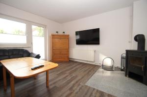 a living room with a couch and a table and a tv at Seewolf - a16900 in Dahme