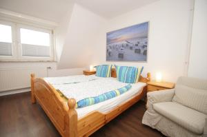 a bedroom with a wooden bed and a chair at Seewolf - a16900 in Dahme