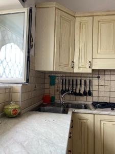 a kitchen with white cabinets and a sink and a window at GIARDINO SUL MARE in Amalfi