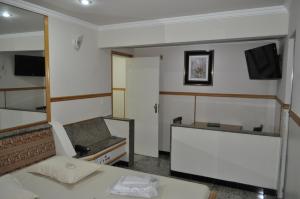 a room with a bed and a couch and a tv at Hotel Casa Blanca - Adults Only in Rio de Janeiro