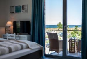 a bedroom with a bed and a view of the ocean at Ostsee - Appartement Nr 80 "MeerSinn" im Strand Resort in Heiligenhafen