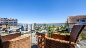 a balcony with two chairs and a view of a street at Ostsee - Appartement Nr 80 "MeerSinn" im Strand Resort in Heiligenhafen