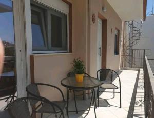 a patio with a table and chairs on a balcony at Luxury and Cozy Chios in Chios