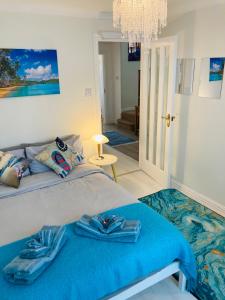 a bedroom with a bed with a blue blanket at Stunning Seafront House with garden and private parking in Eastbourne