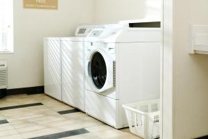 eine weiße Waschmaschine und ein Trockner in einer Waschküche in der Unterkunft Candlewood Suites Lafayette, an IHG Hotel in Lafayette