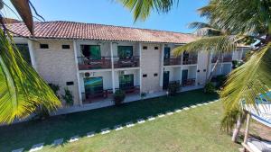 an exterior view of a building with palm trees at Porto Bali Hotel in Santa Cruz Cabrália