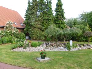 a garden with rocks and flowers in a yard at Ferienhof Frohne - Kornspeicher in Merzen