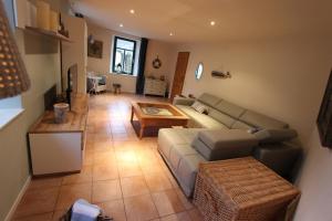 ein Wohnzimmer mit einem Sofa und einem Tisch in der Unterkunft Ferienhaus Bettina in Stolberg