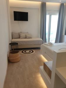 a living room with a couch and a tv at Hotel Alexandra in Skala
