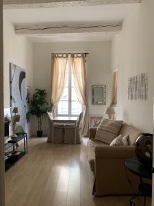 sala de estar con sofá y ventana en Apartment Limas en Aviñón