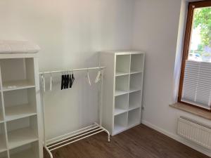 a white closet with white shelves and a window at Strand24 in Ostseebad Nienhagen