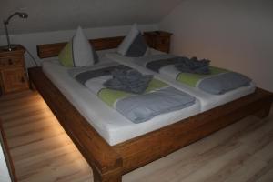 a large wooden bed with two pillows on it at Ferienwohnung mit Balkon in Sehmatal