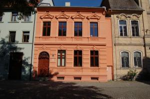 a large orange building with a door on a street at Ferienwohnung am Saalebogen in Calbe
