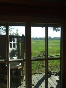 een raam met uitzicht op een veld buiten bij Bauwagen in Kirch Mulsow