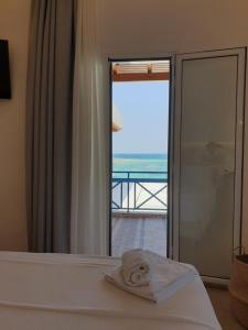 a bedroom with a bed with a view of the ocean at Hotel Alexandra in Skala