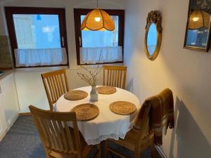 einen Esstisch mit einem weißen Tischtuch und Stühlen in der Unterkunft Altstadthaus zur Weide in Heiligenhafen