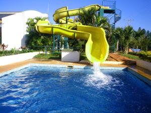 a yellow water slide in a swimming pool at Hotel Berro D´Agua in Avaré