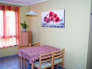 a dining room with a table and a painting of red flowers at Hütigendachs, FW 5 in Zingst