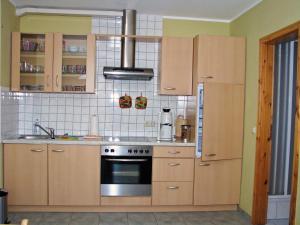 a kitchen with wooden cabinets and a stove at Hütigendachs, FW 5 in Zingst