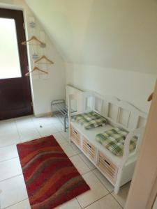 a bedroom with two white beds and a rug at Finnhäuser am Vogelpark - Haus Elke in Marlow