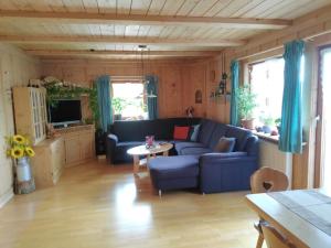 uma sala de estar com um sofá azul e uma mesa em Sommerruhe em Titisee-Neustadt