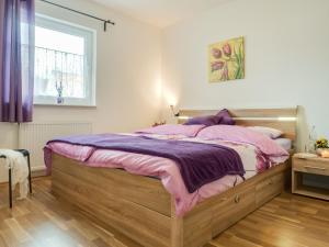 a bedroom with a large bed with purple sheets at Wiesenstraße 2 Whg 1 in Zingst