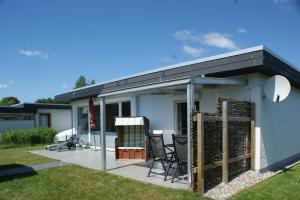 a house with a patio with a roof at Fehmarn-Ostseeferien FH3Traumbungalow Staberdorf 137 in Staberdorf