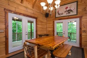 a dining room with a wooden table and windows at A Touch of Luxury in Lake Lure