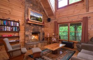 a living room with a stone fireplace in a log cabin at A Touch of Luxury in Lake Lure