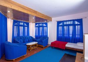 a living room with blue furniture and blue curtains at Hotel Paradiso in Kalimpong