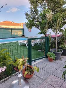 a fence with potted plants and a swimming pool at Bem Me Quer in Almada