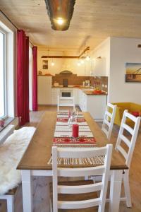 - une salle à manger et une cuisine avec une table et des chaises en bois dans l'établissement Ferienhaus Rotdorn - Haus Süd, à Strukkamp auf Fehmarn