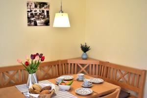 einen Esstisch mit einer Vase Tulpen drauf in der Unterkunft Am Hof 3 in Staberdorf