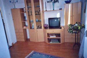 ein Wohnzimmer mit einem TV und einigen Holzschränken in der Unterkunft Mündlein in Eckernförde