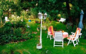 einen Garten mit Stühlen, einem Tisch und einem Sonnenschirm in der Unterkunft Mündlein in Eckernförde