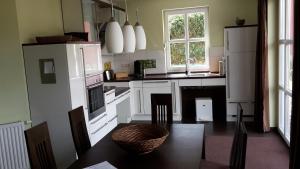 a kitchen with white appliances and a table with chairs at Häuschen "Tante Waltraut" - a29317 in Garz-Usedom