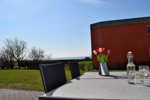 a table with a bottle of wine and flowers on it at Fehmarnstrand 78 App 10 in Staberdorf