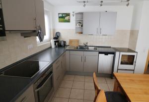 a kitchen with white cabinets and a sink and a table at Haus Findling, 10 Personen, Schluchsee, Hochschwarzwaldkarte in Schluchsee