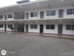 a large white building with a balcony and a patio at Hotel & Suites Mo Sak in Tapachula