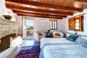two beds in a room with a fireplace at Malvasia Traditional Hotel in Monemvasia