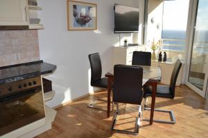 - une cuisine et une salle à manger avec une table et des chaises dans l'établissement Traumblick FeWo Nr 459, à Sierksdorf