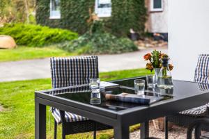 un tavolo nero con due sedie e un vaso di fiori di Fischereihof Liebe - 69177 a Süsel